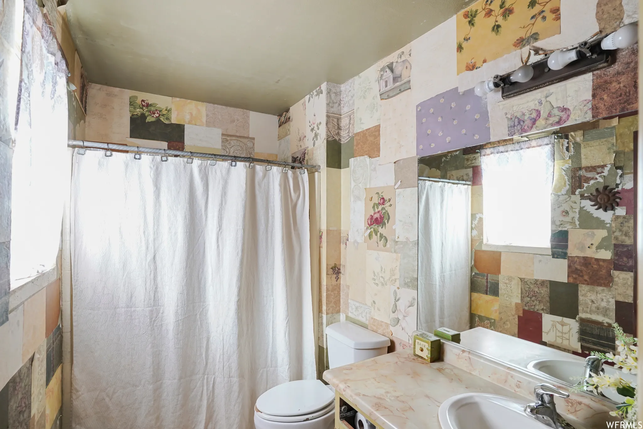 Bathroom with vanity, toilet, and tile walls