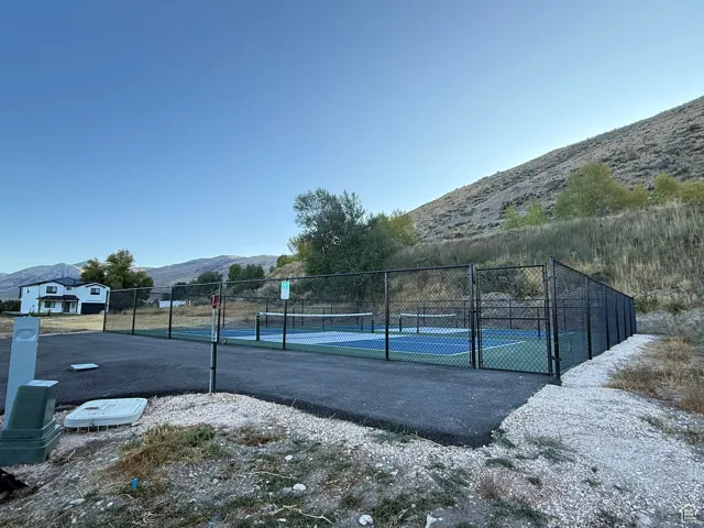 View of sport court with a mountain view and a tennis court