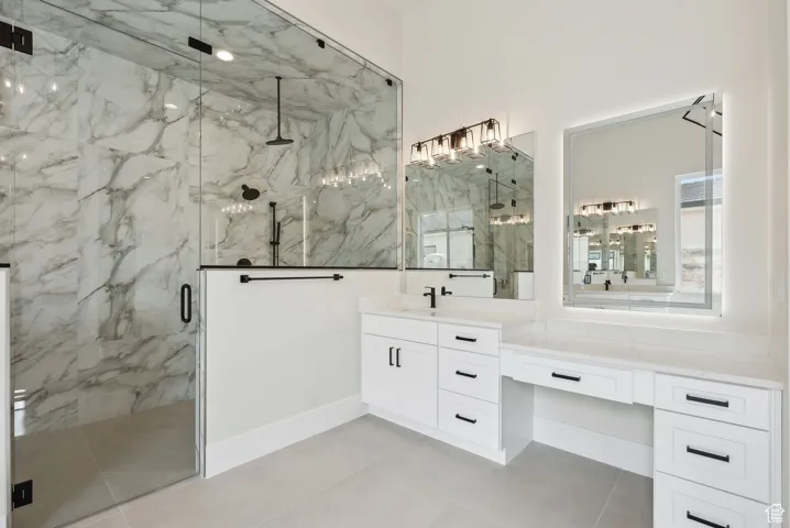 Full bathroom featuring tile patterned floors, a marble finish shower, and vanity