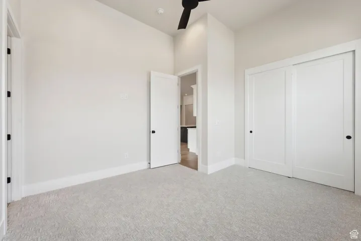 Unfurnished bedroom featuring a closet, carpet flooring, and baseboards