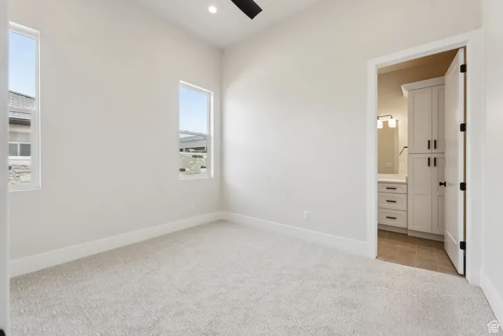 Unfurnished bedroom with baseboards, light carpet, and connected bathroom