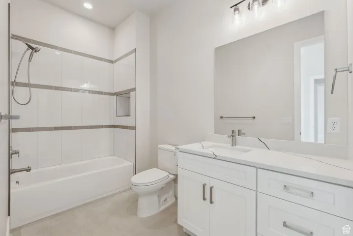 Bathroom with recessed lighting, vanity, shower / bathtub combination, and toilet