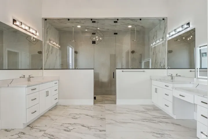 grand master bathroom with drop down vanity and backlit mirror