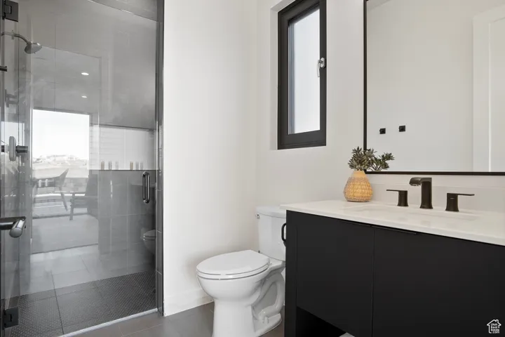 Bathroom with a shower with door, oversized vanity, and toilet