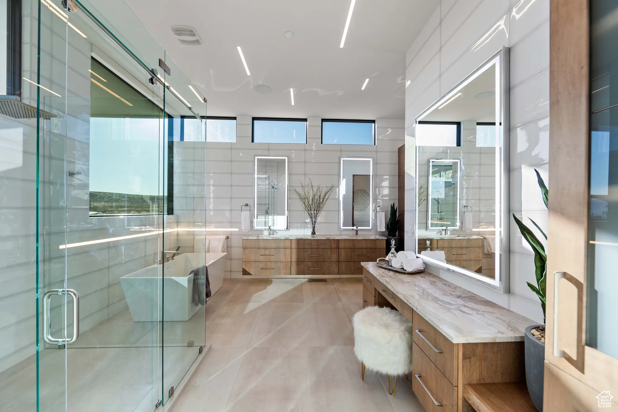 Bathroom with tile flooring, independent shower and bath, vanity, and tile walls
