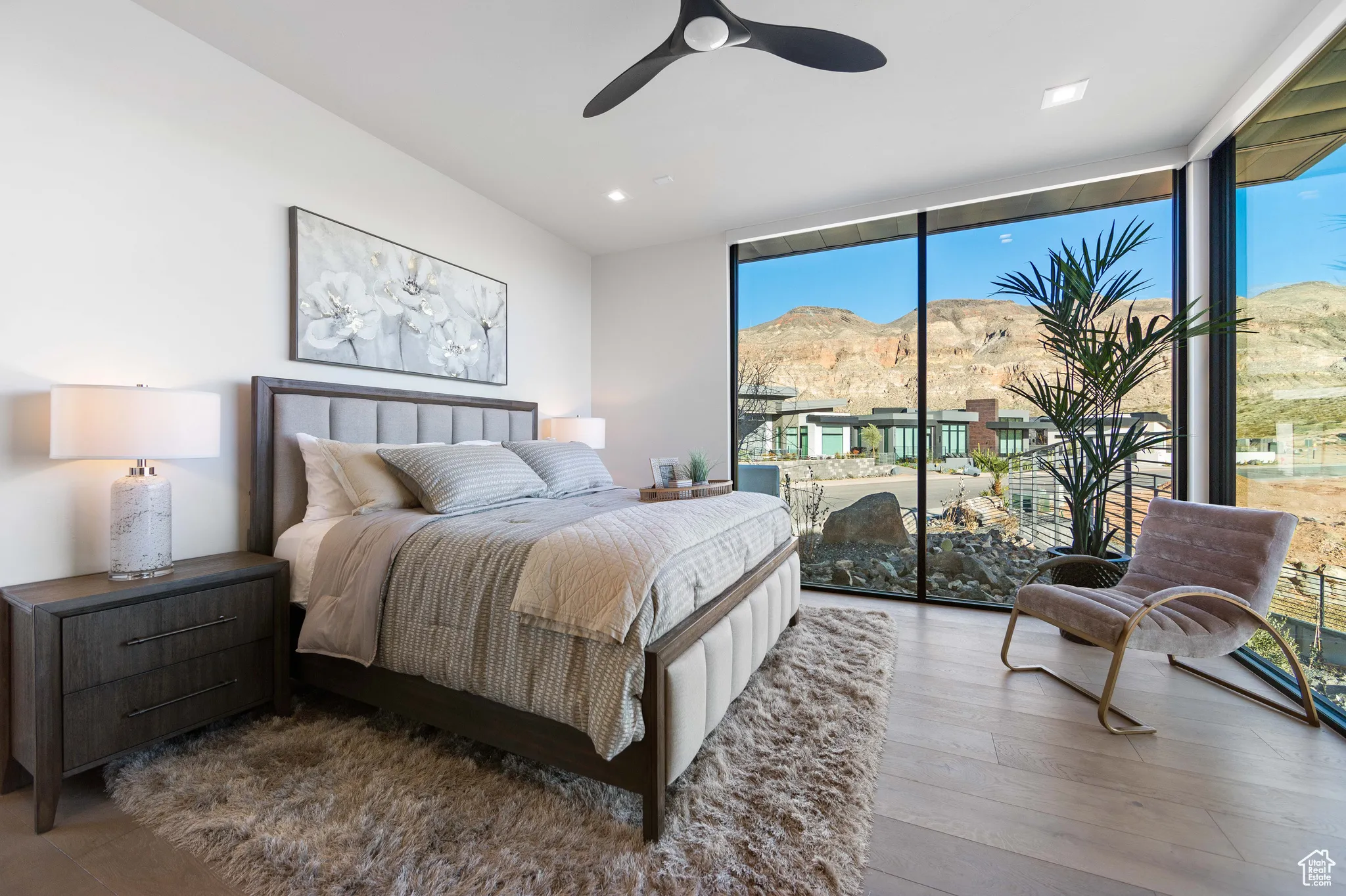 Bedroom with ceiling fan, a mountain view, access to exterior, expansive windows, and wood-type flooring
