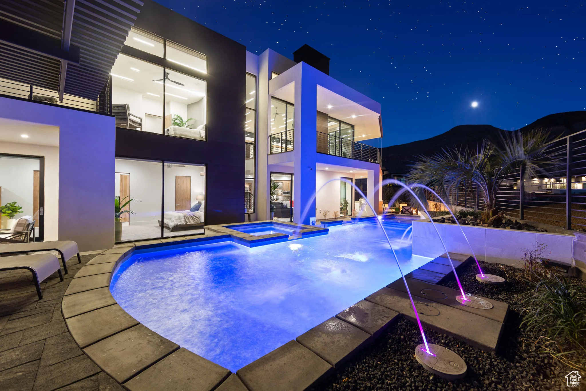 Pool at twilight featuring pool water feature and a patio area