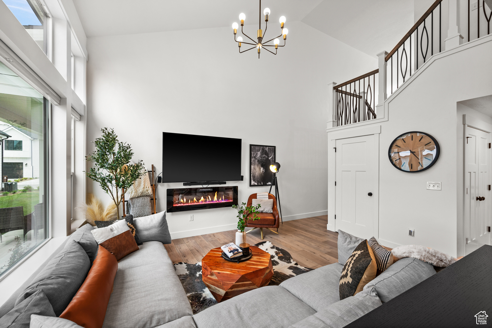 Living room featuring a chandelier, light hardwood / wood-style floors, and high vaulted ceiling