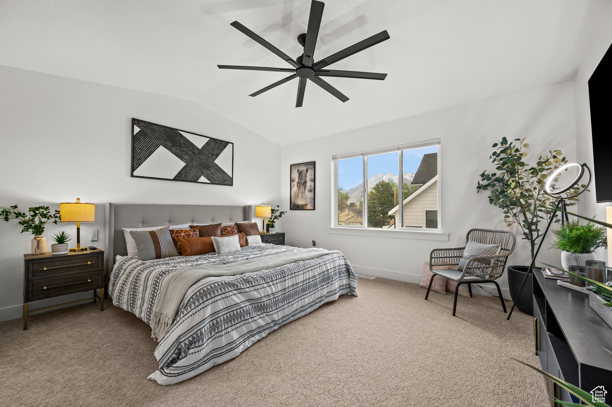 Carpeted bedroom featuring vaulted ceiling and ceiling fan