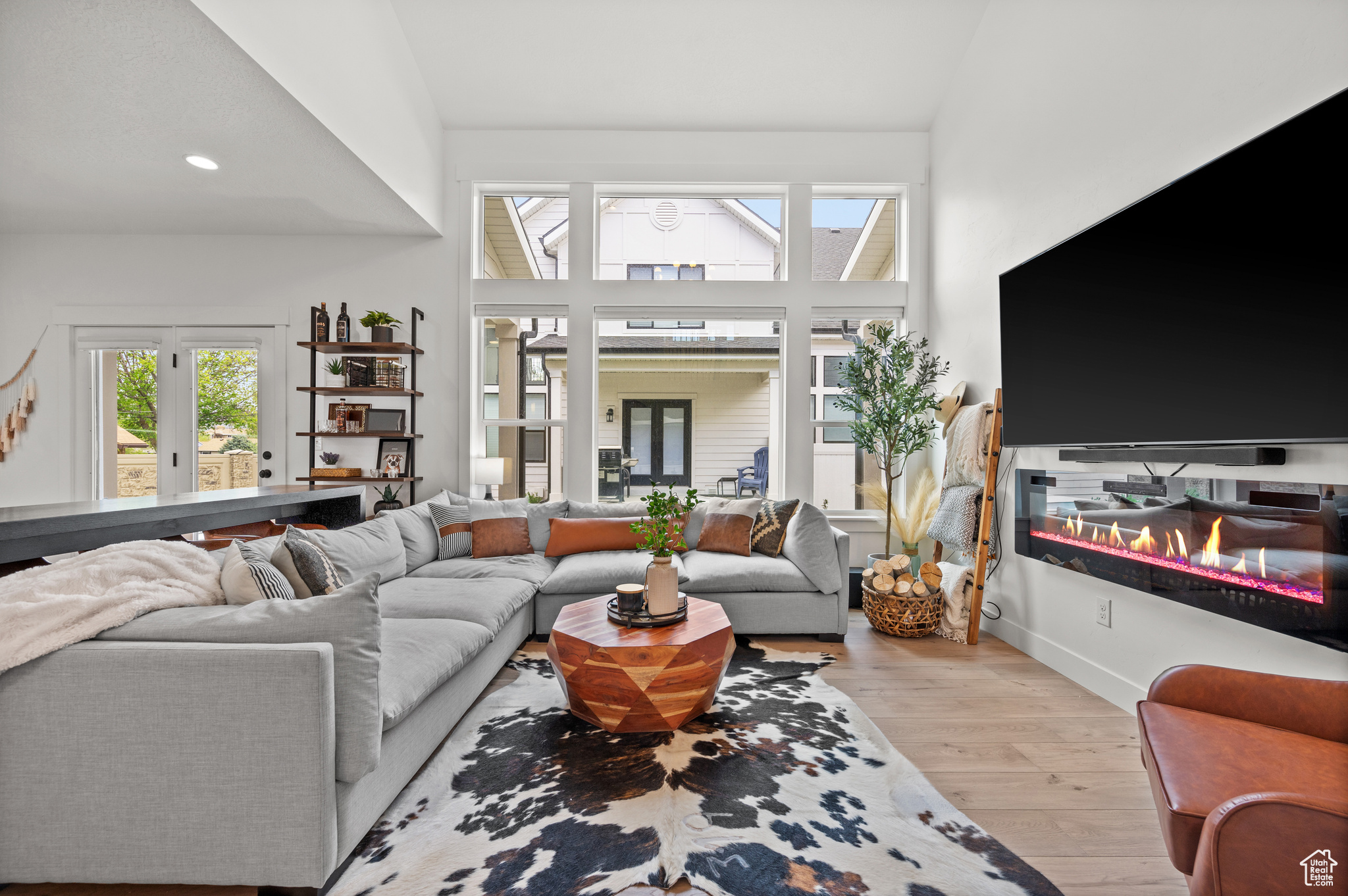 Living room with light hardwood / wood-style floors and high vaulted ceiling