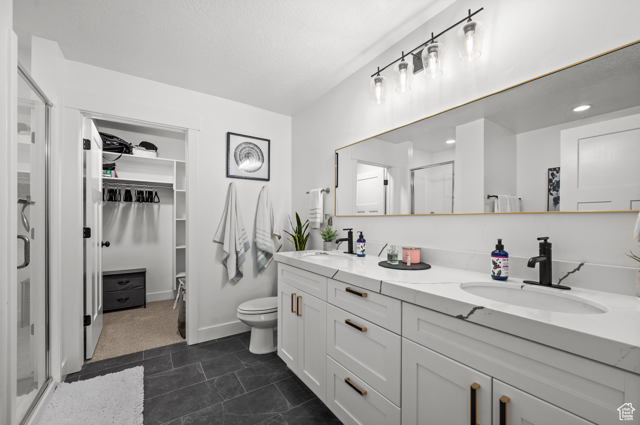 Bathroom with tile flooring, large vanity, toilet, and dual sinks
