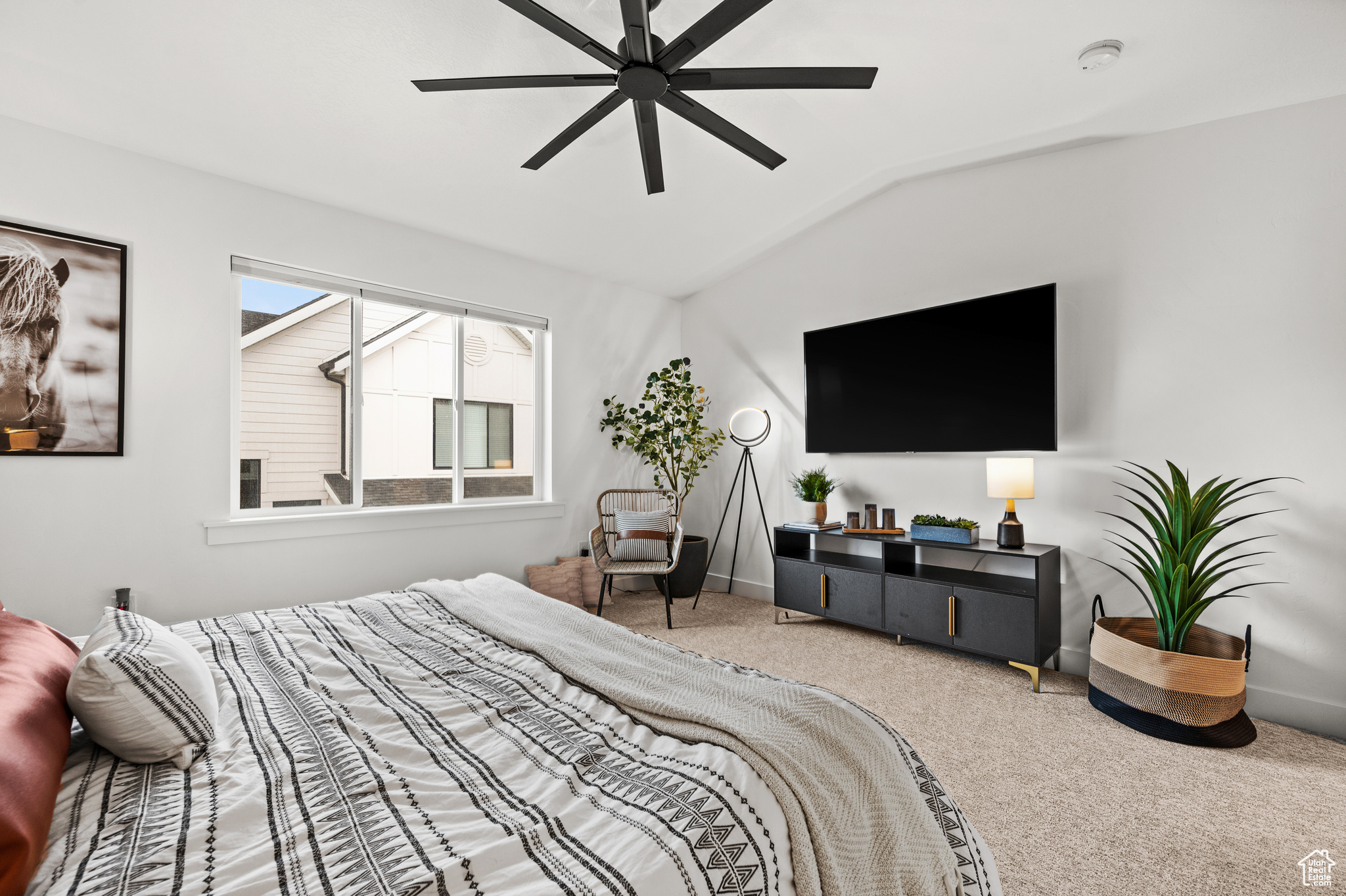 Carpeted bedroom with lofted ceiling and ceiling fan