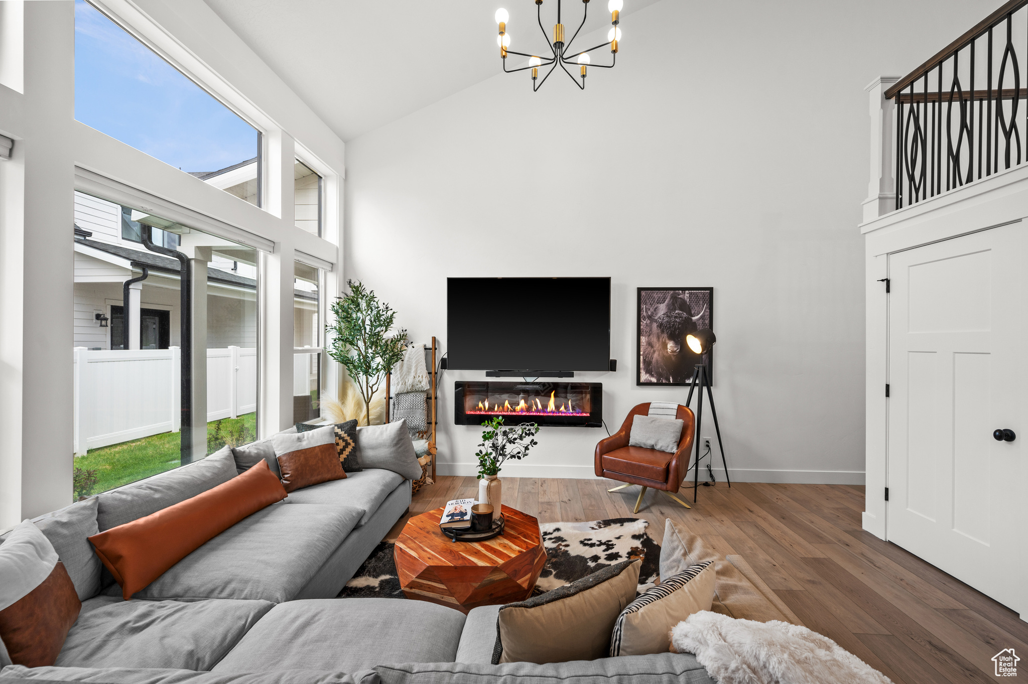 Living room featuring a chandelier, dark hardwood / wood-style floors, a wealth of natural light, and high vaulted ceiling