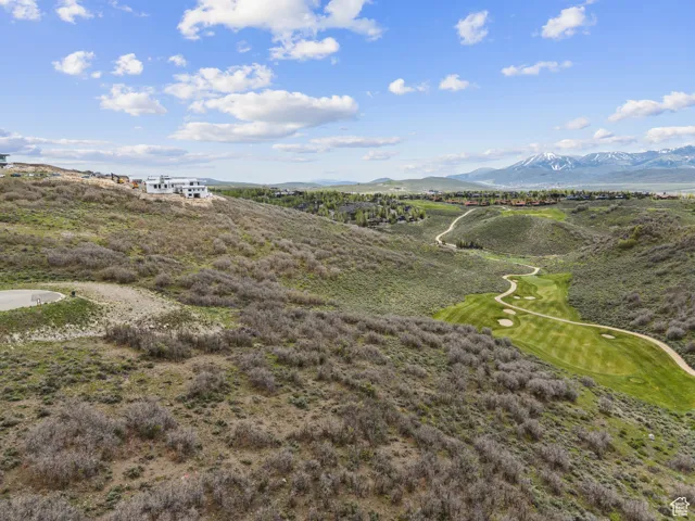 Drone / aerial view of a mountain backdrop and a golf course
