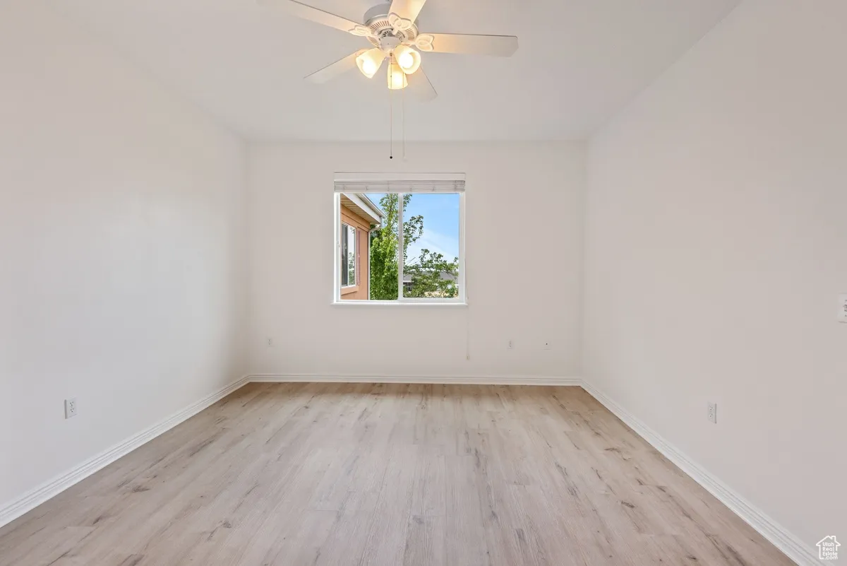 Unfurnished room with ceiling fan and light hardwood / wood-style flooring