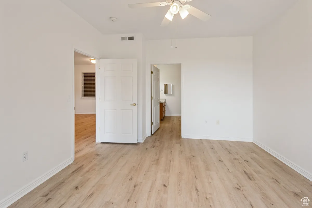 Empty room with light wood-type flooring and ceiling fan