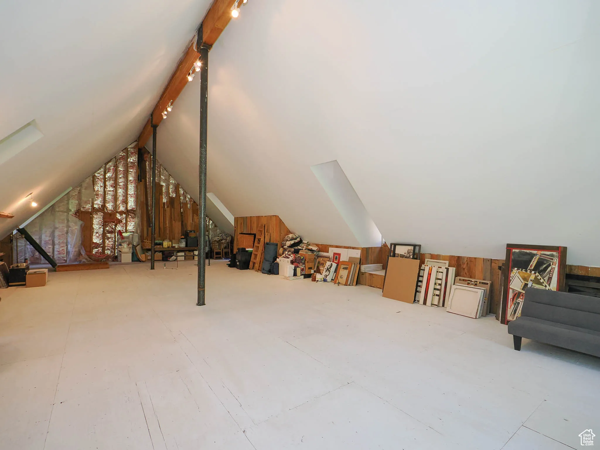 A-frame attic space with stubbed plumbing and exposed structural steel support columns