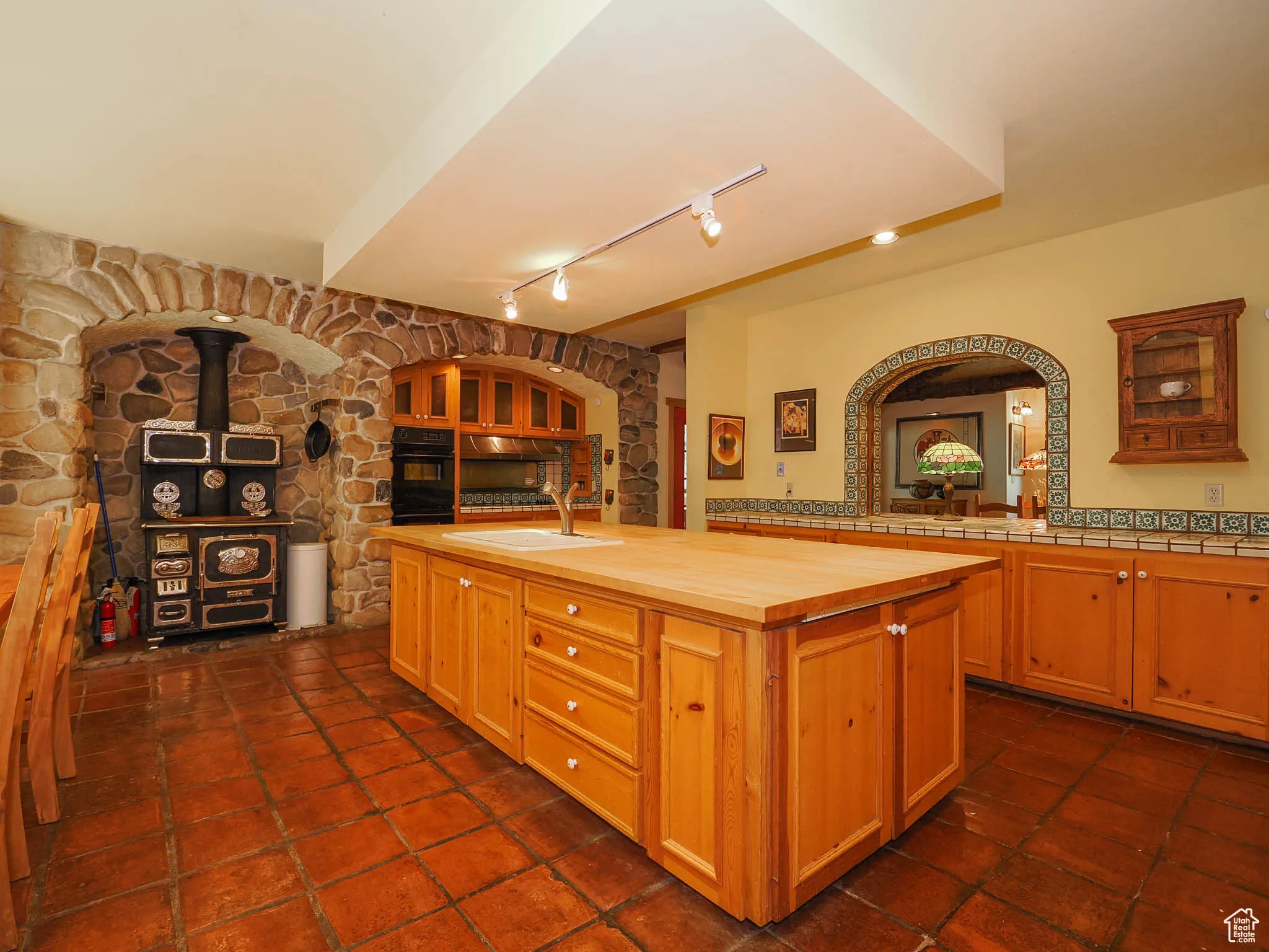 Kitchen tile floors, stone arches, wood-burning stove