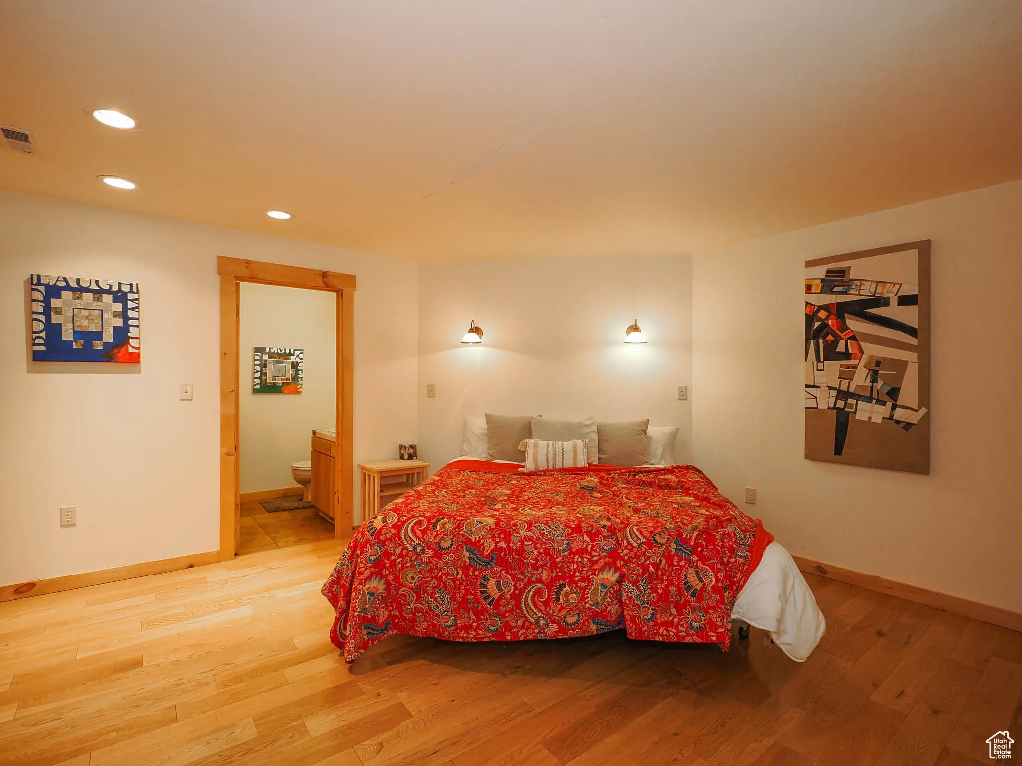 Large basement primary bedroom with wood floors