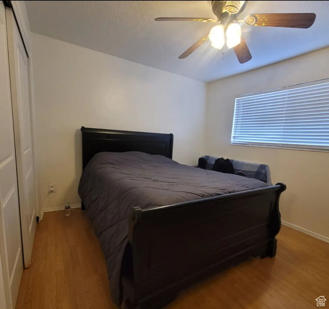 Bedroom featuring light hardwood / wood-style floors, a closet, and ceiling fan