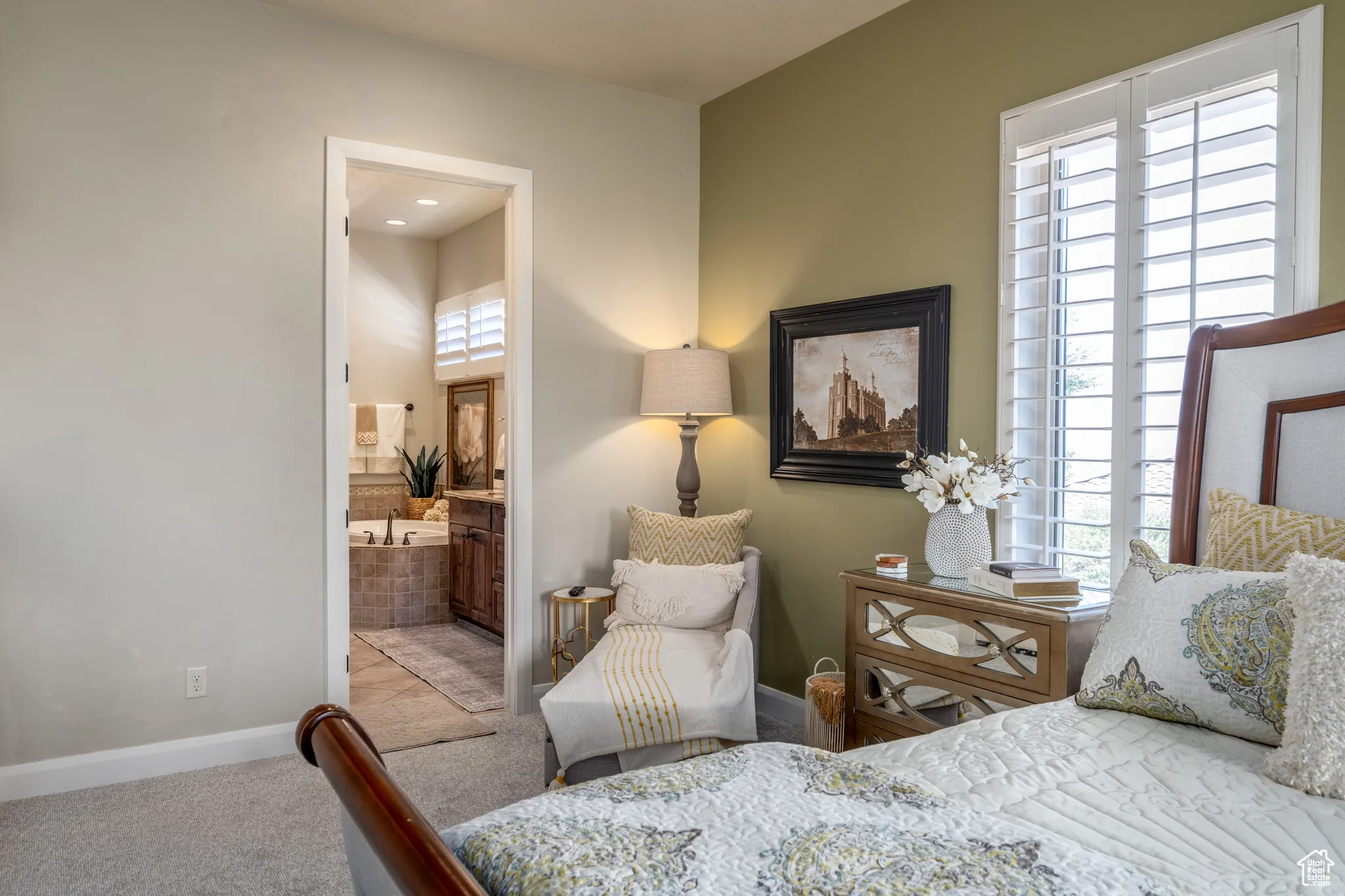 Bedroom featuring ensuite bathroom and carpet flooring