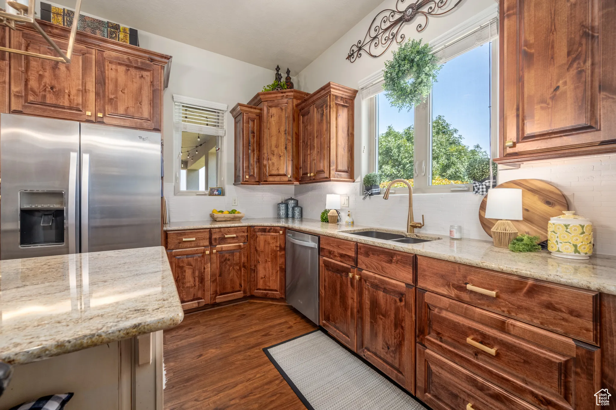 Kitchen with dark hardwood / wood-style floors, dishwasher, plenty of natural light, and refrigerator