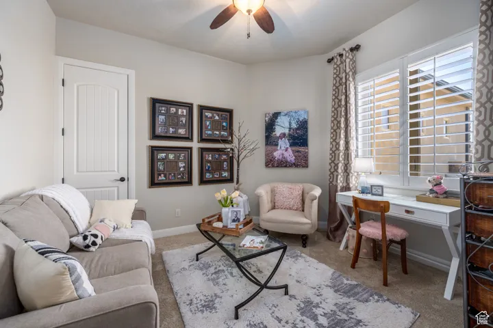 Living room featuring carpet and ceiling fan