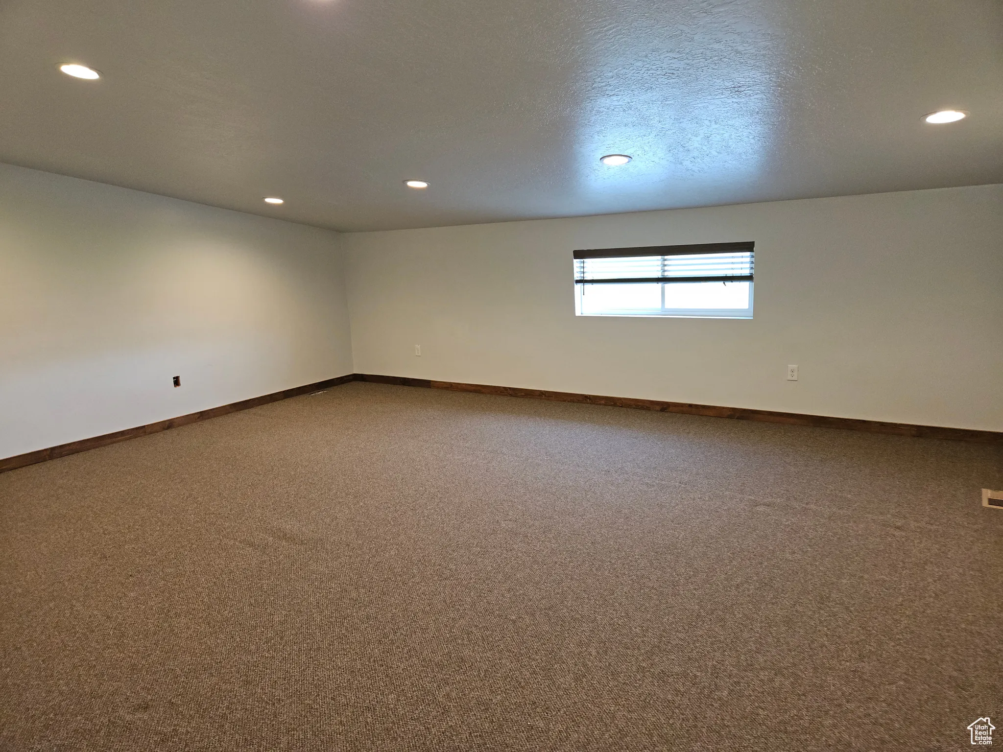 Spare room featuring recessed lighting, carpet floors, and baseboards