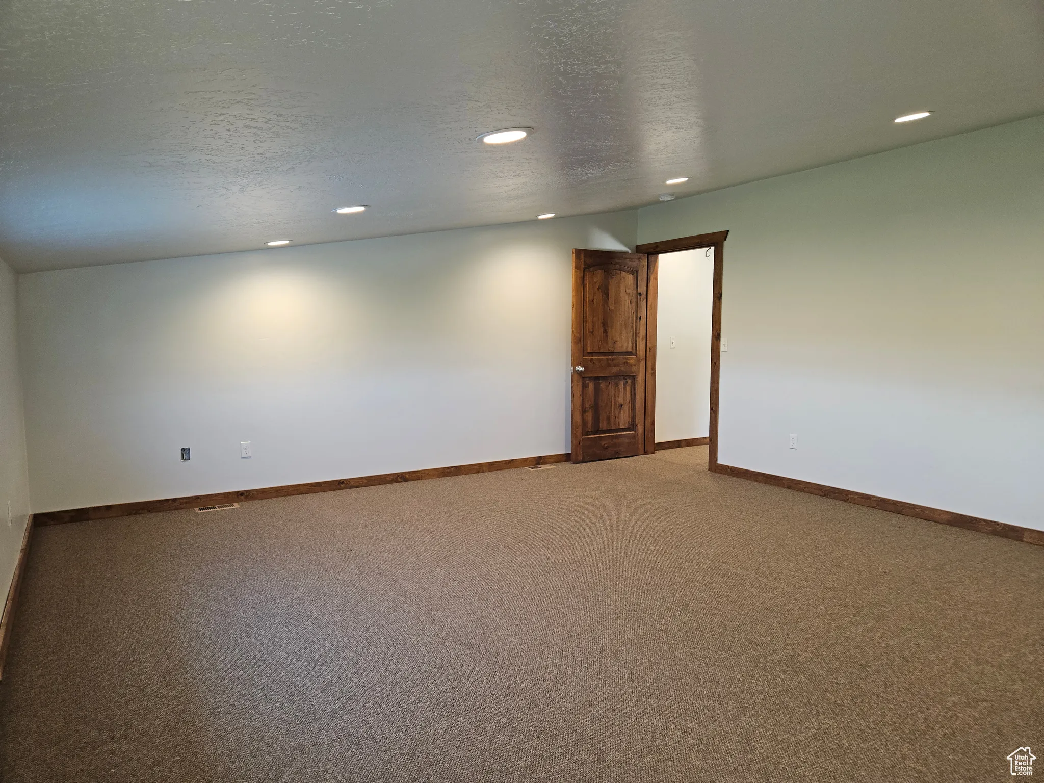 Carpeted empty room with recessed lighting and baseboards