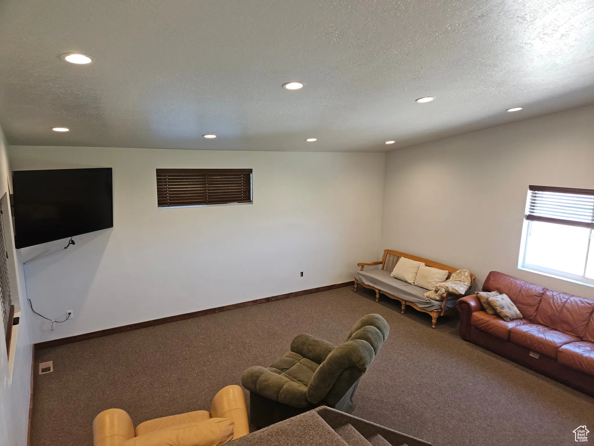 Carpeted living room featuring recessed lighting, a textured ceiling, and baseboards