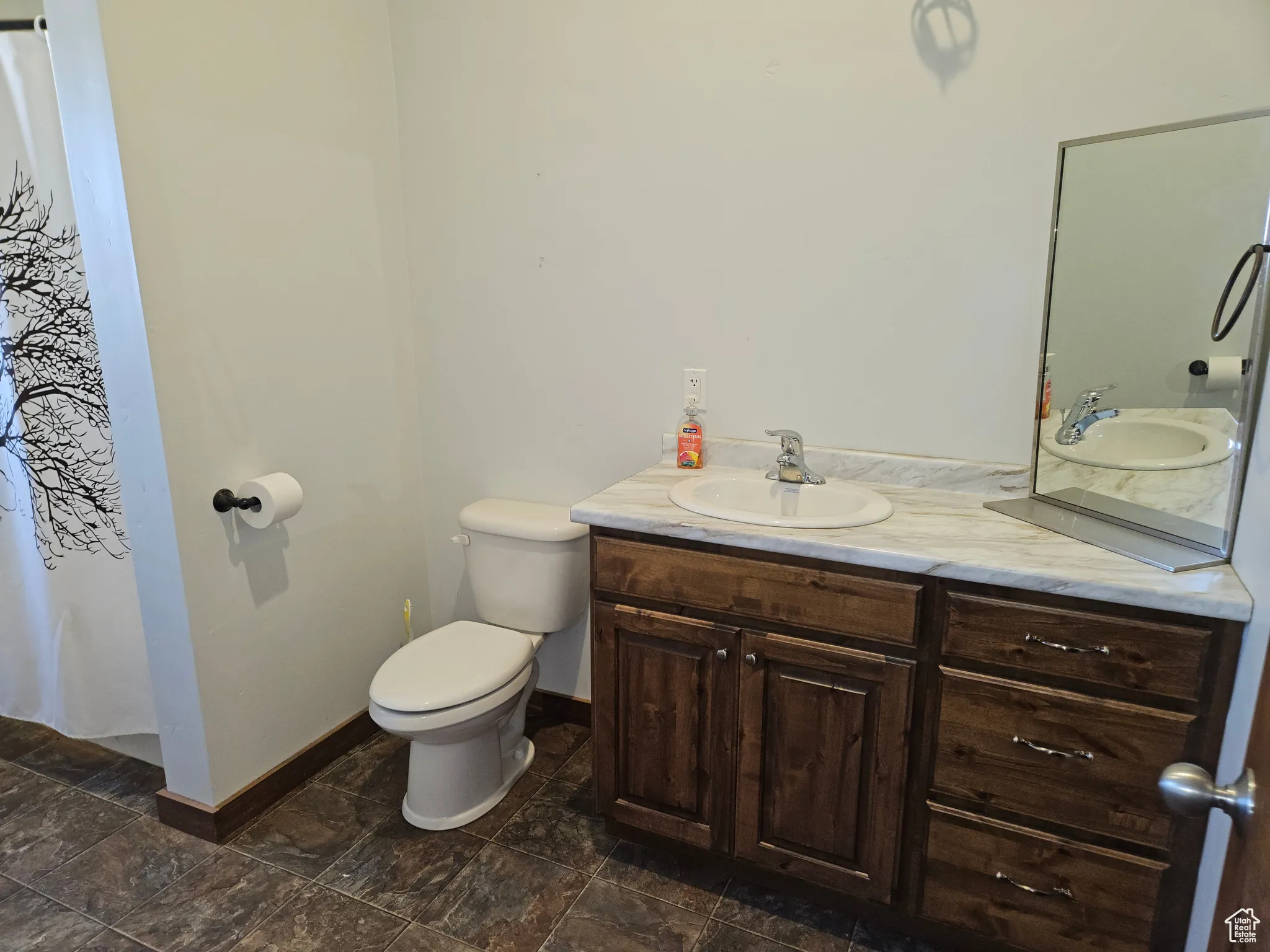 Full bathroom with vanity, toilet, and baseboards