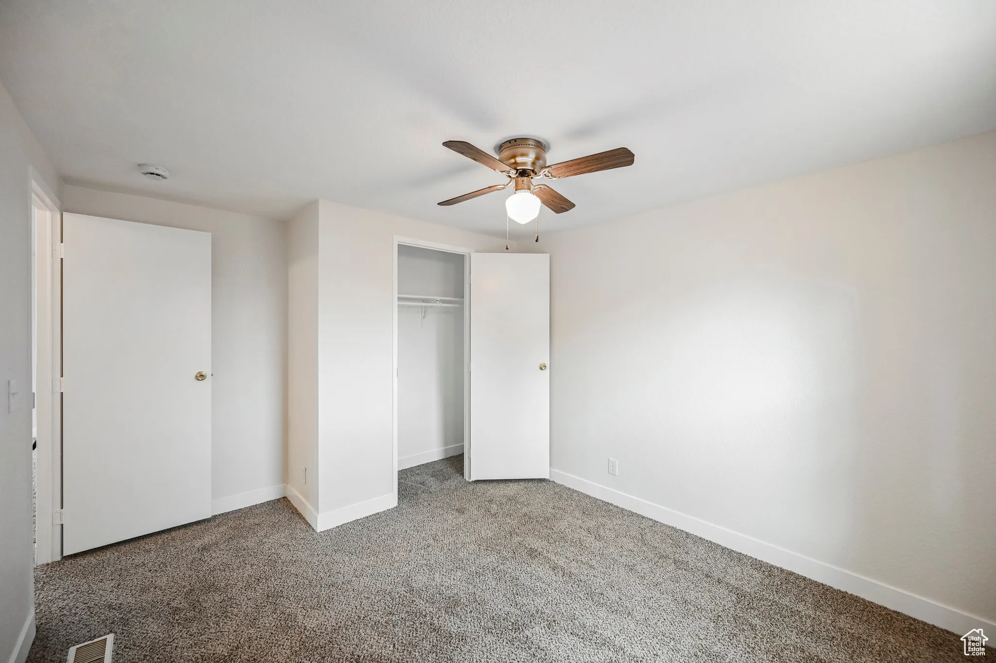 Unfurnished bedroom featuring a closet, ceiling fan, and carpet floors