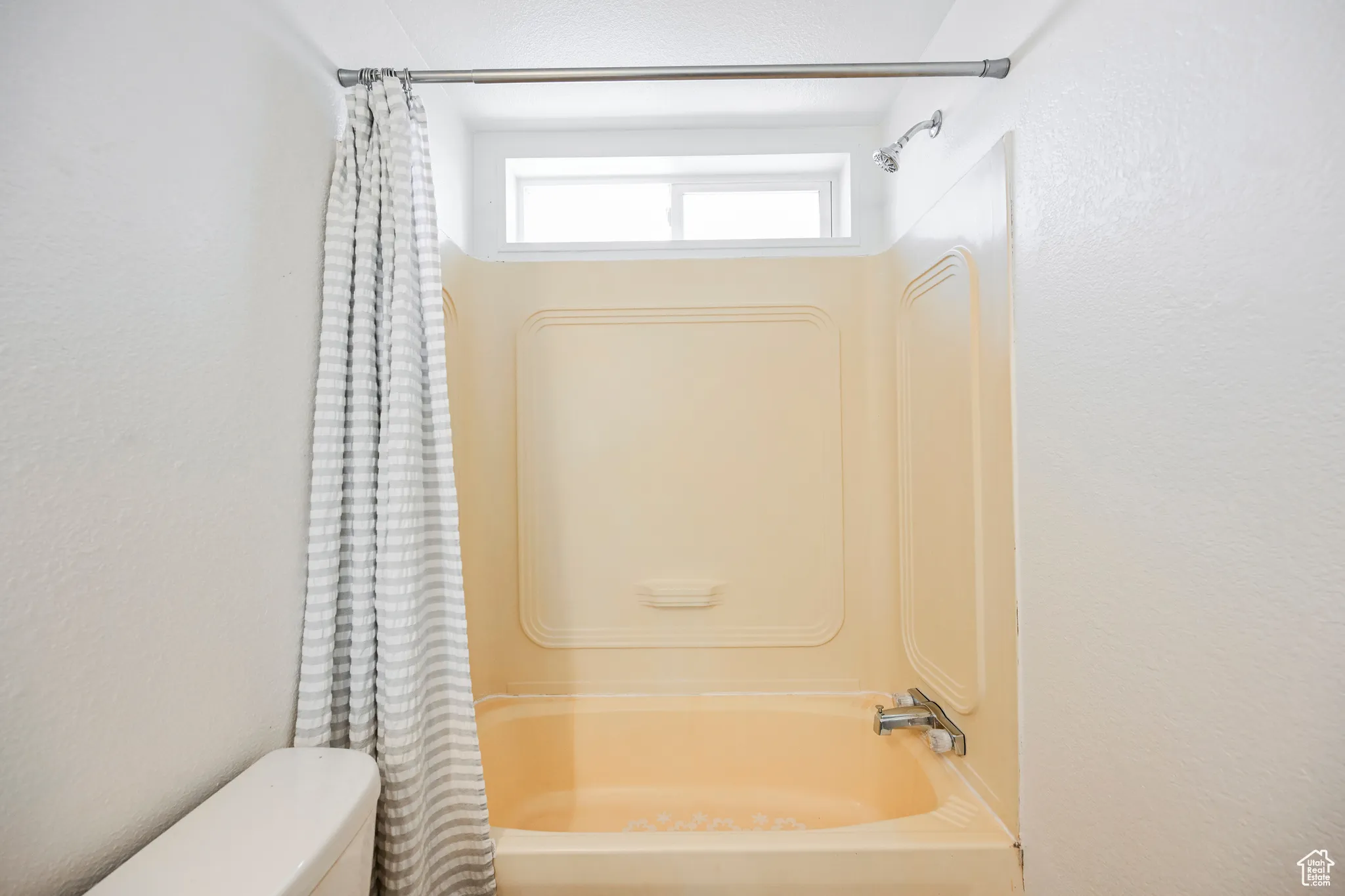 Bathroom featuring shower / bath combo with shower curtain and toilet