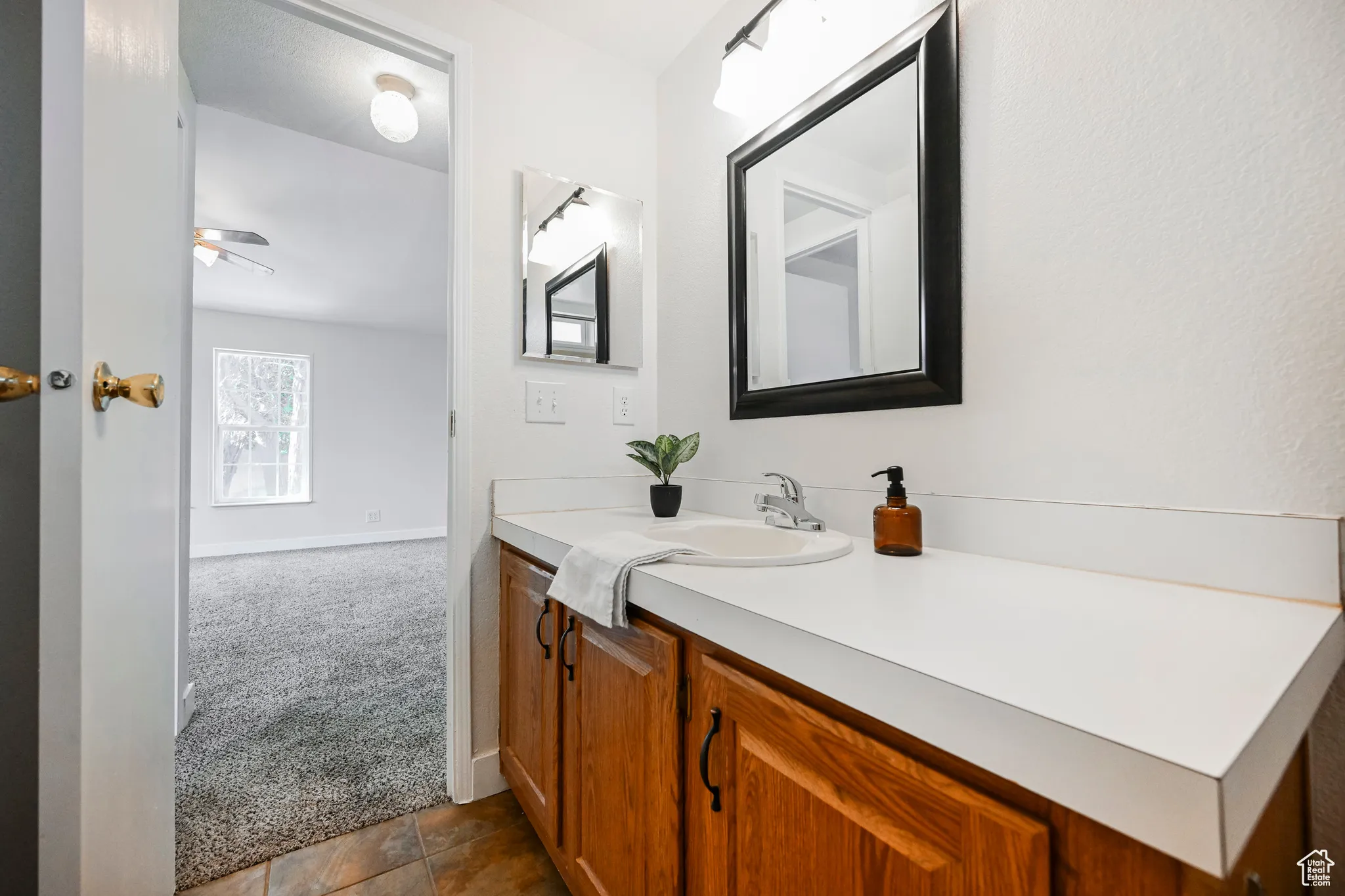 Bathroom featuring ceiling fan, vanity, and tile patterned flooring