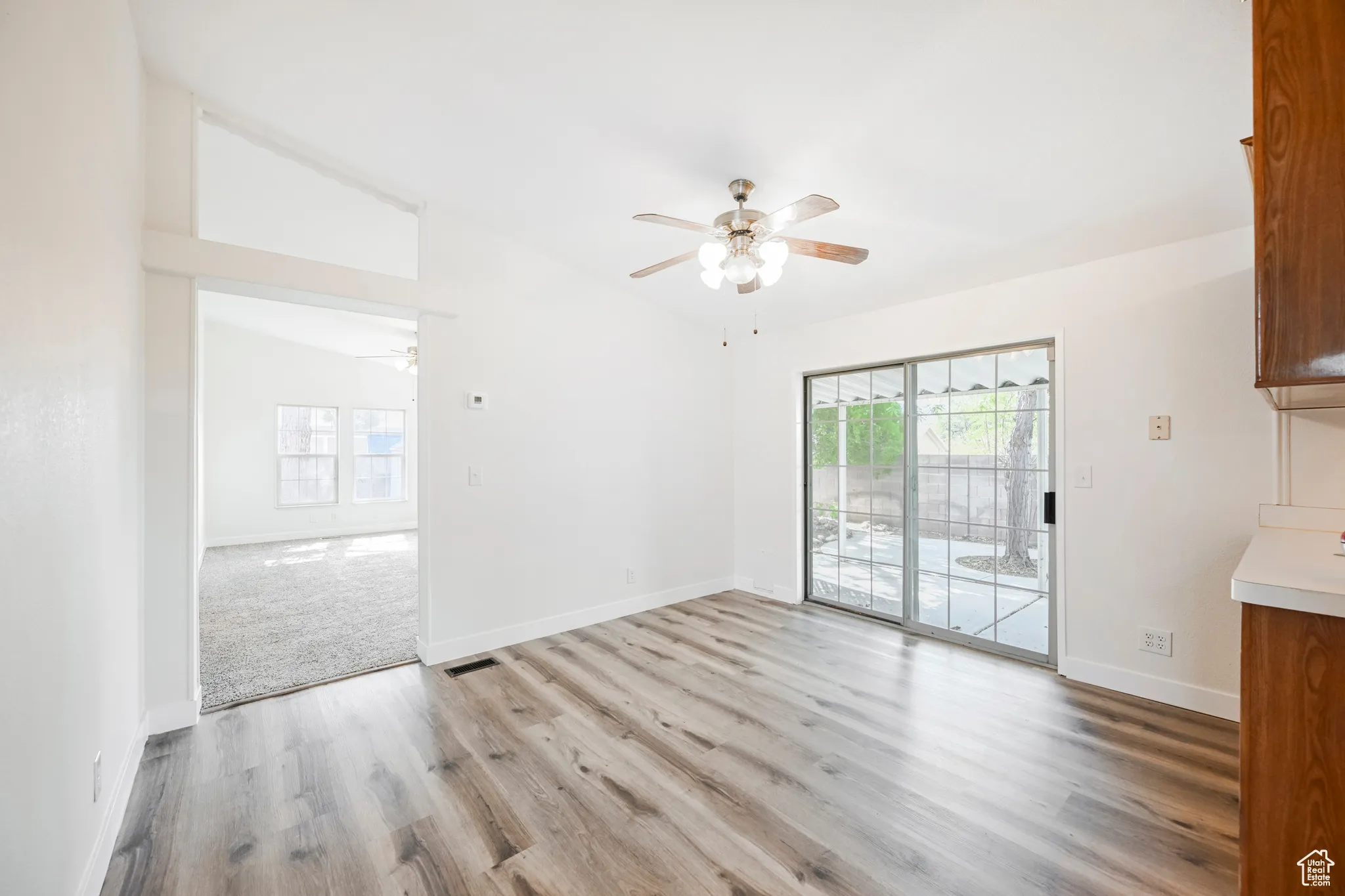 Interior space with ceiling fan, lofted ceiling, and light colored carpet