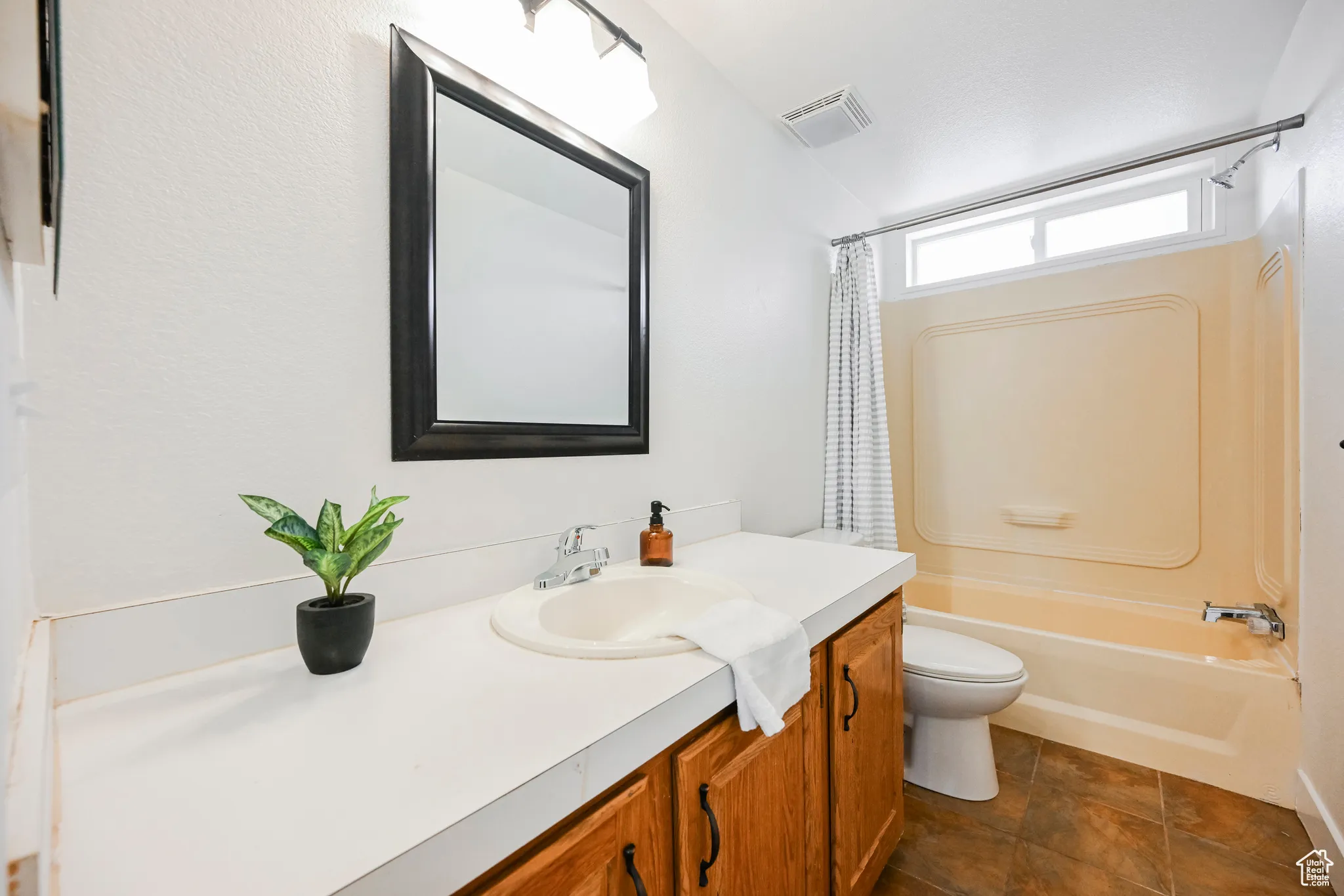 Full bathroom with tile patterned floors, vanity, toilet, and shower / bath combo