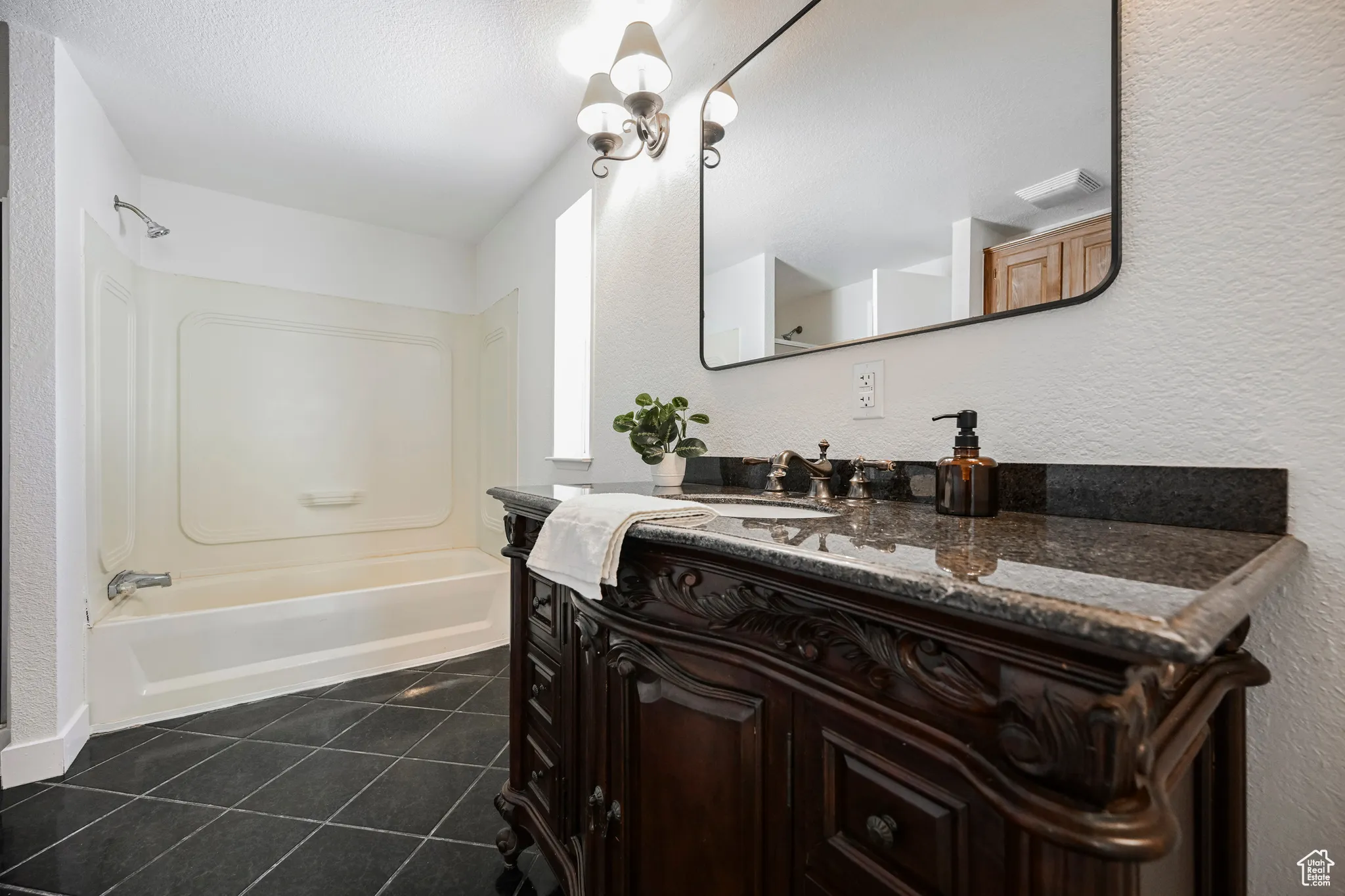 Bathroom featuring  shower combination, vanity, and tile patterned flooring