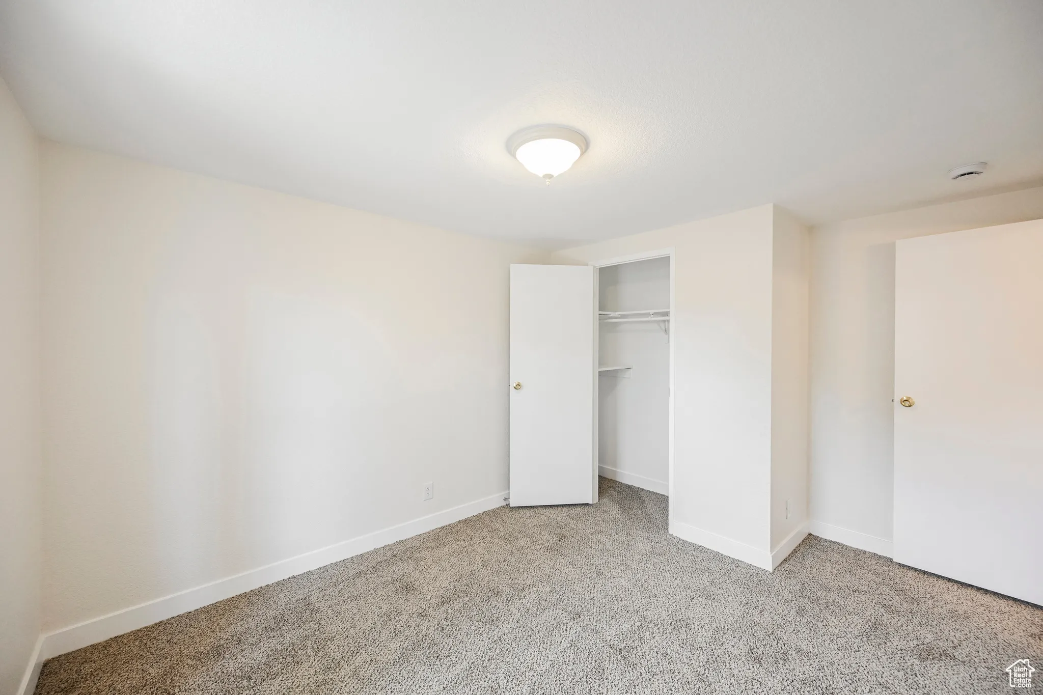 Unfurnished bedroom with a closet and light colored carpet