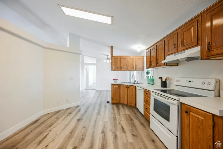 Kitchen featuring light hardwood / wood-style flooring, white appliances, vaulted ceiling, and ceiling fan