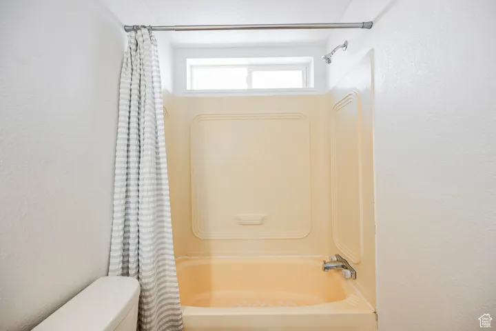 Bathroom featuring shower / bath combo with shower curtain and toilet