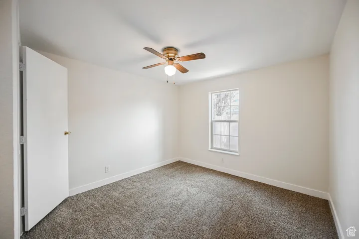 Spare room featuring ceiling fan and carpet floors