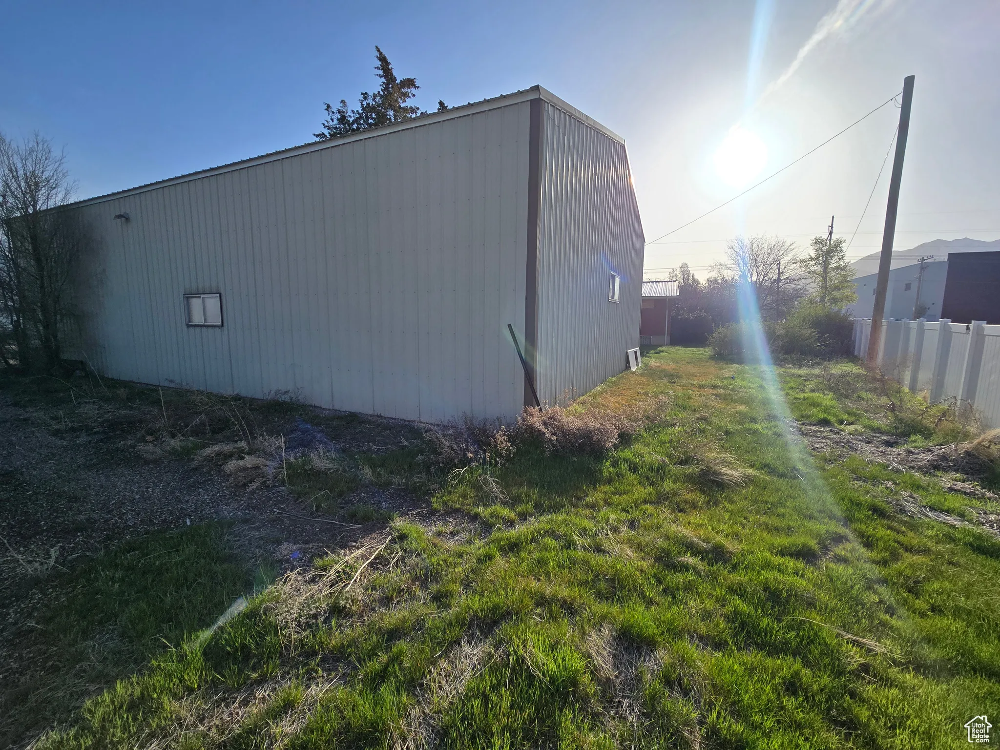 View of home's exterior featuring fence and an outbuilding