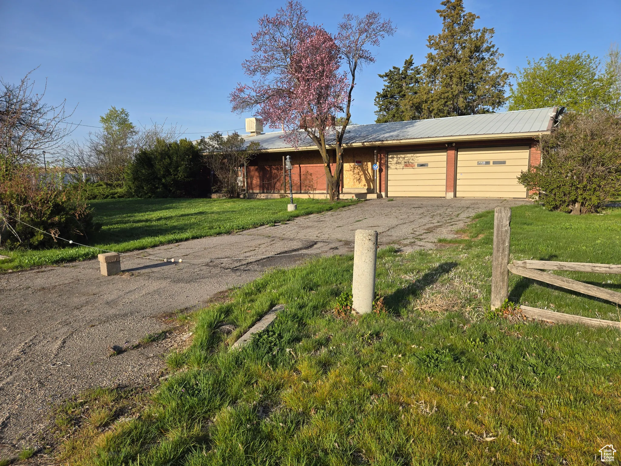 View of front of property with a garage, a front yard, fence, and aphalt driveway