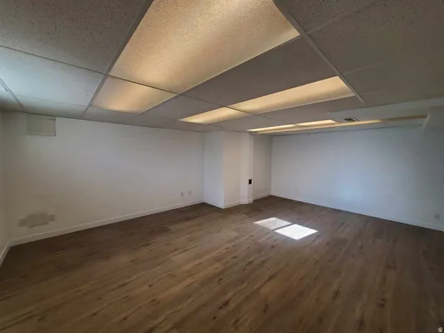 basement living- room with a drop ceiling and brand new LVP wood finished floors