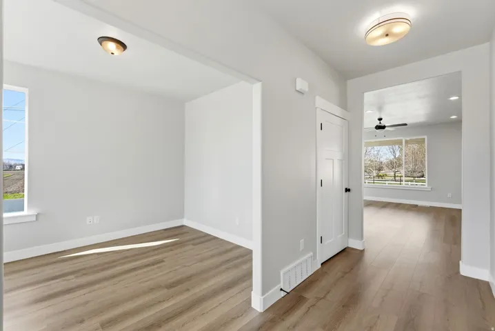 Empty room with light wood-style flooring and a ceiling fan