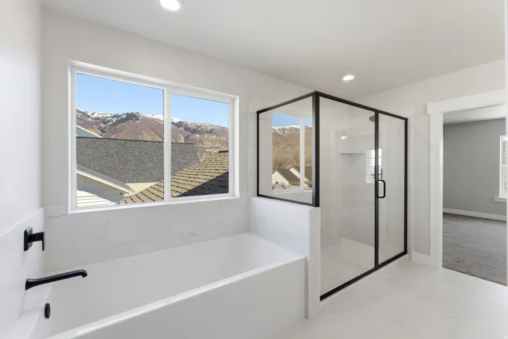 Bathroom featuring a shower stall, a garden tub, a mountain view, and recessed lighting