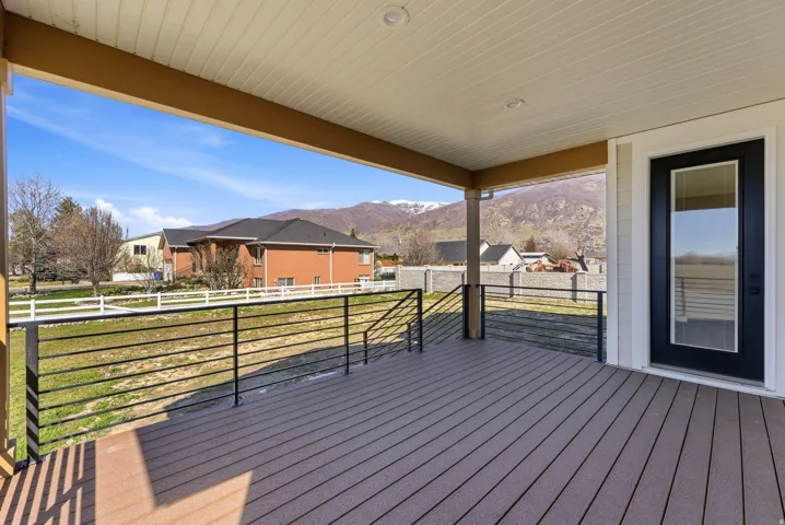 Deck with a mountain view, a residential view, and a yard