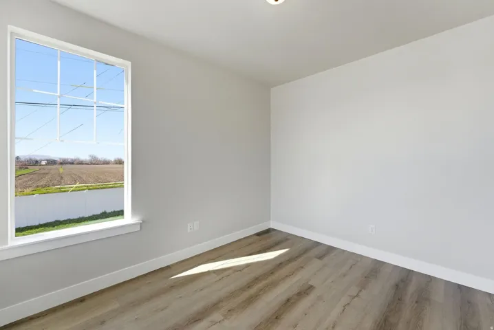 Empty room with light wood-style flooring and baseboards