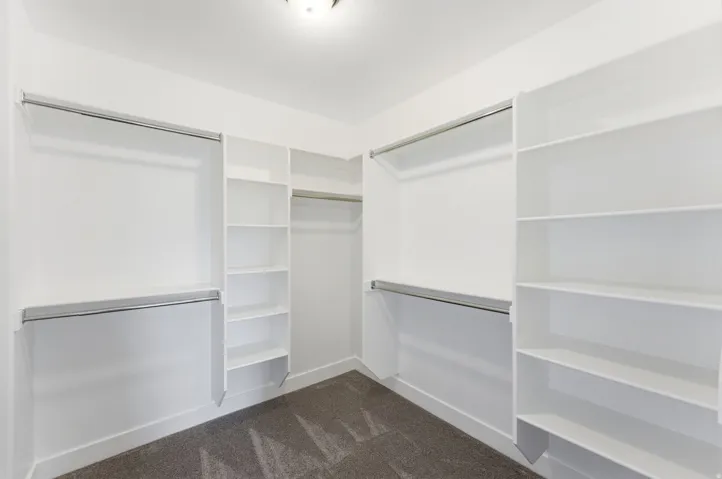 Walk in closet featuring dark carpet