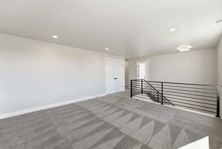 Empty room featuring light carpet and recessed lighting